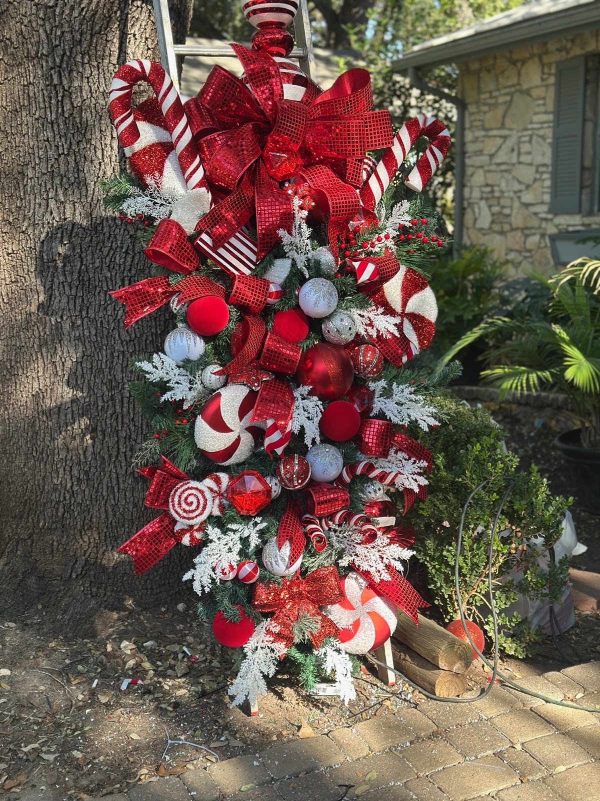 Candy-themed Christmas tree styling with oversized ribbon, peppermint and ornaments