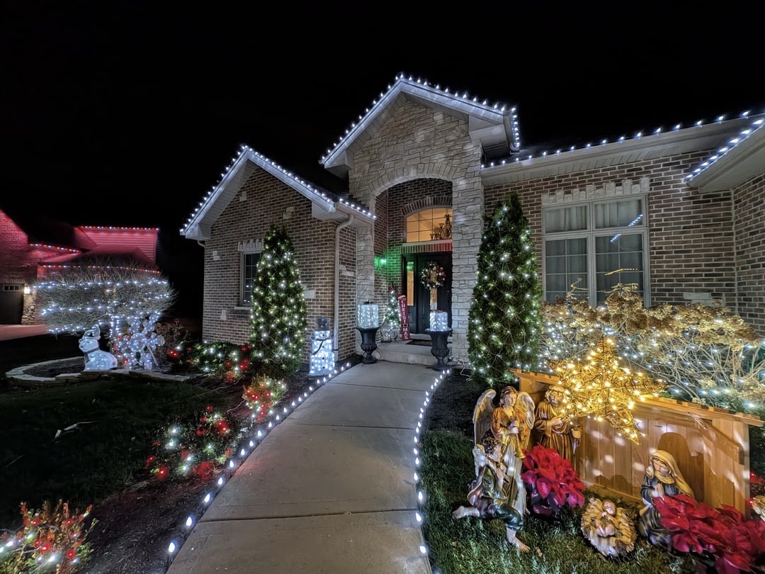 Warm white Christmas lights running the roofline and peaks of a Hill Country home